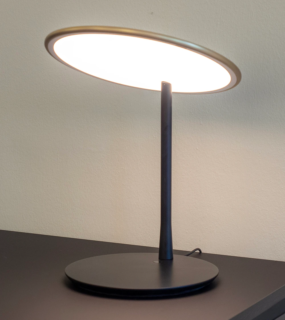 Lámpara de mesa o flexo dorado con luz cálida.