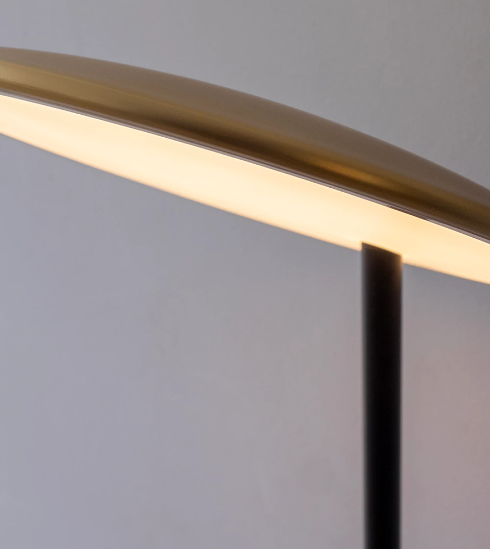 Lámpara de mesa o flexo dorado con luz cálida.