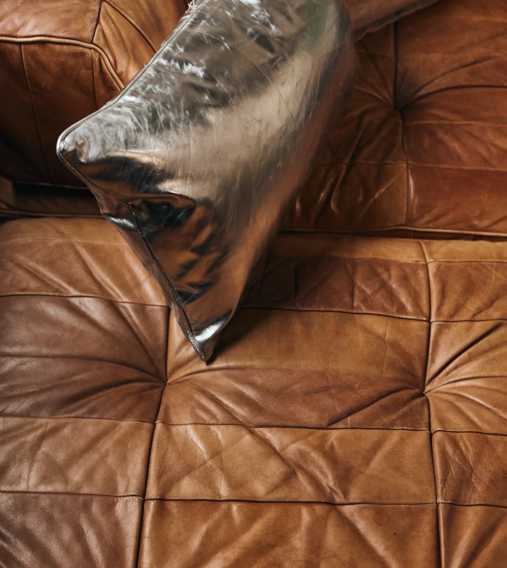 Cojín decorativo efecto metálico de HKLIVING con textura arrugada y acabado brillante sobre sofá