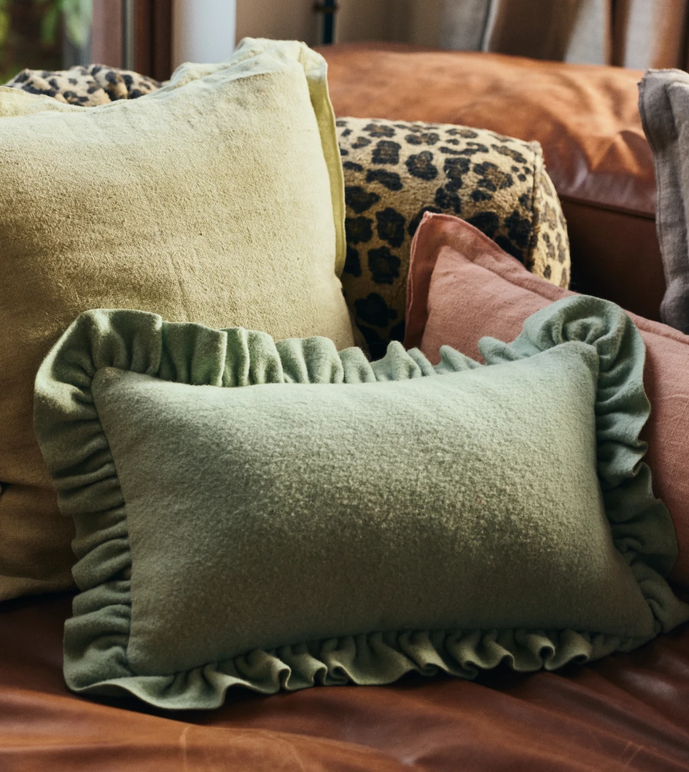 Cojín acolchado con borde fruncido de HKLIVING sobre sofá, aportando confort, textura y estilo decorativo