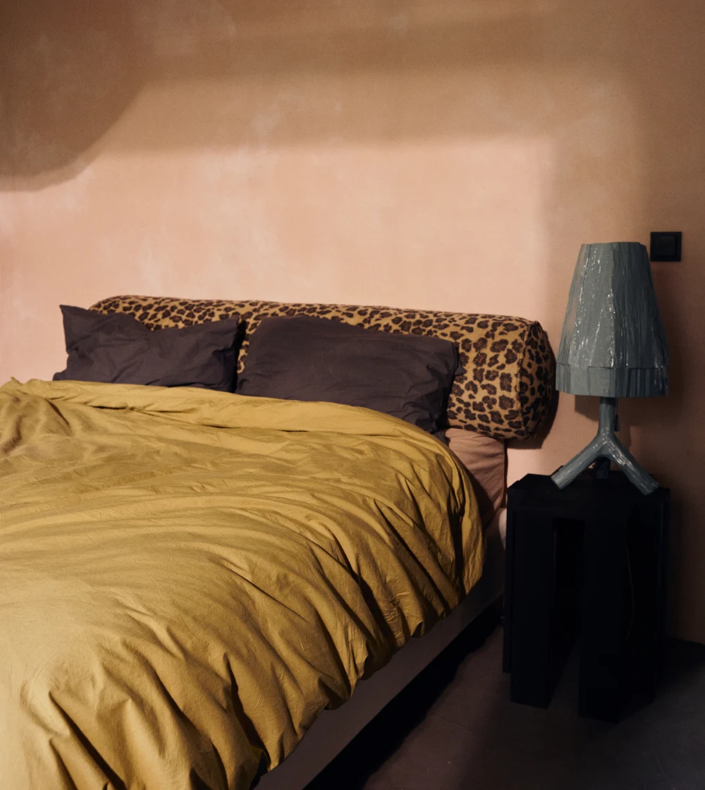 cojín bolster estampado HKLIVING alargado sobre sofá con diseño decorativo llamativo.