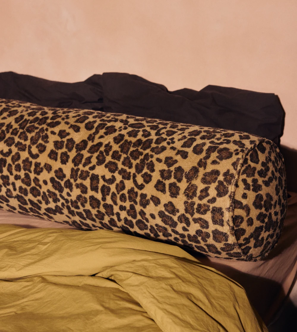 cojín bolster estampado HKLIVING alargado sobre sofá con diseño decorativo llamativo.
