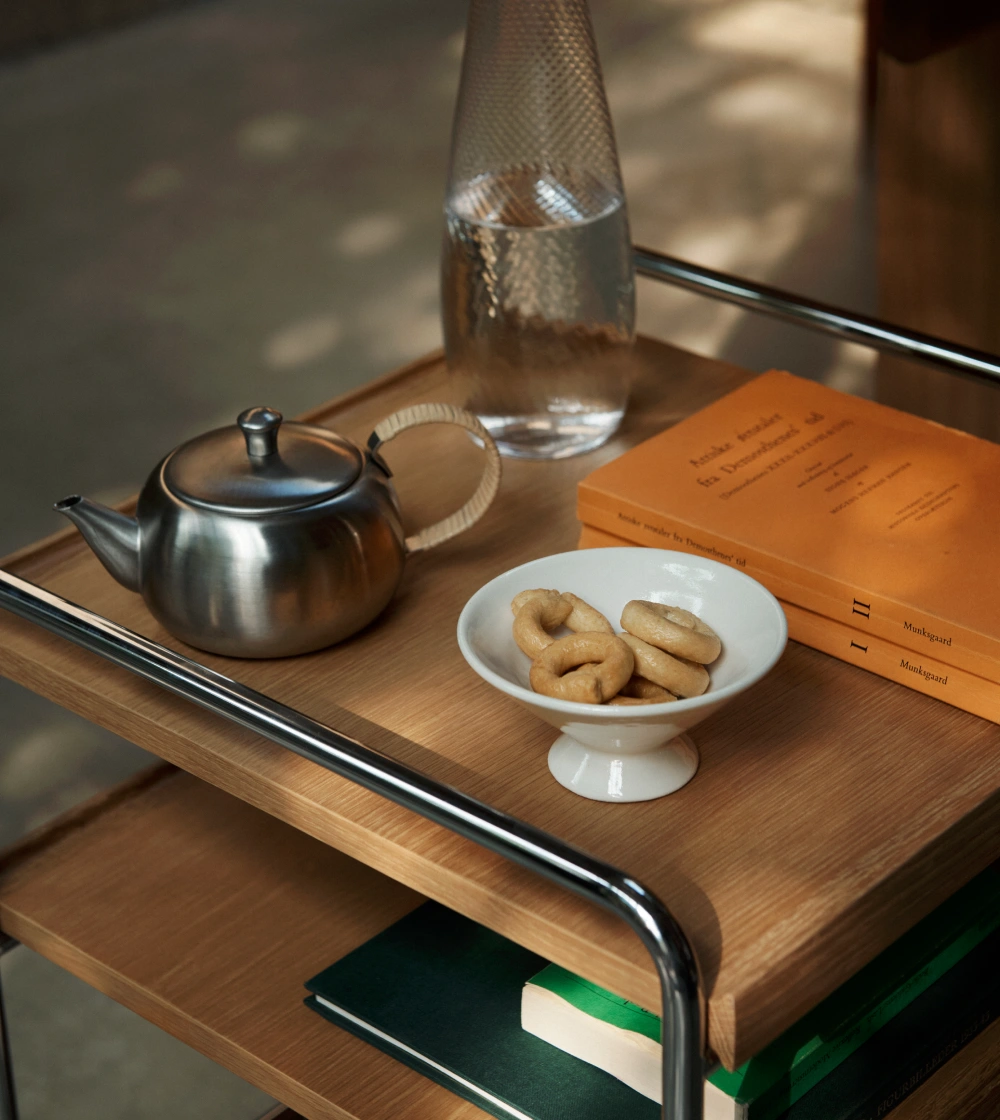 Mesa Trolley Alima de &Tradition con estantes de madera y estructura metálica con ruedas.