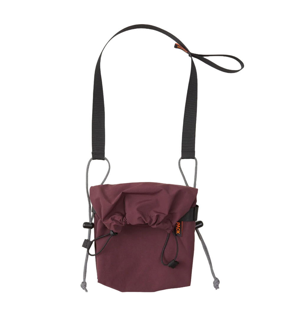 Bolso bandolera pequeño Small Drawstring Sling A110 de PACKBAGS en rojo cinabrio, con cierre de cordón y correa ajustable con detalle reflectante.