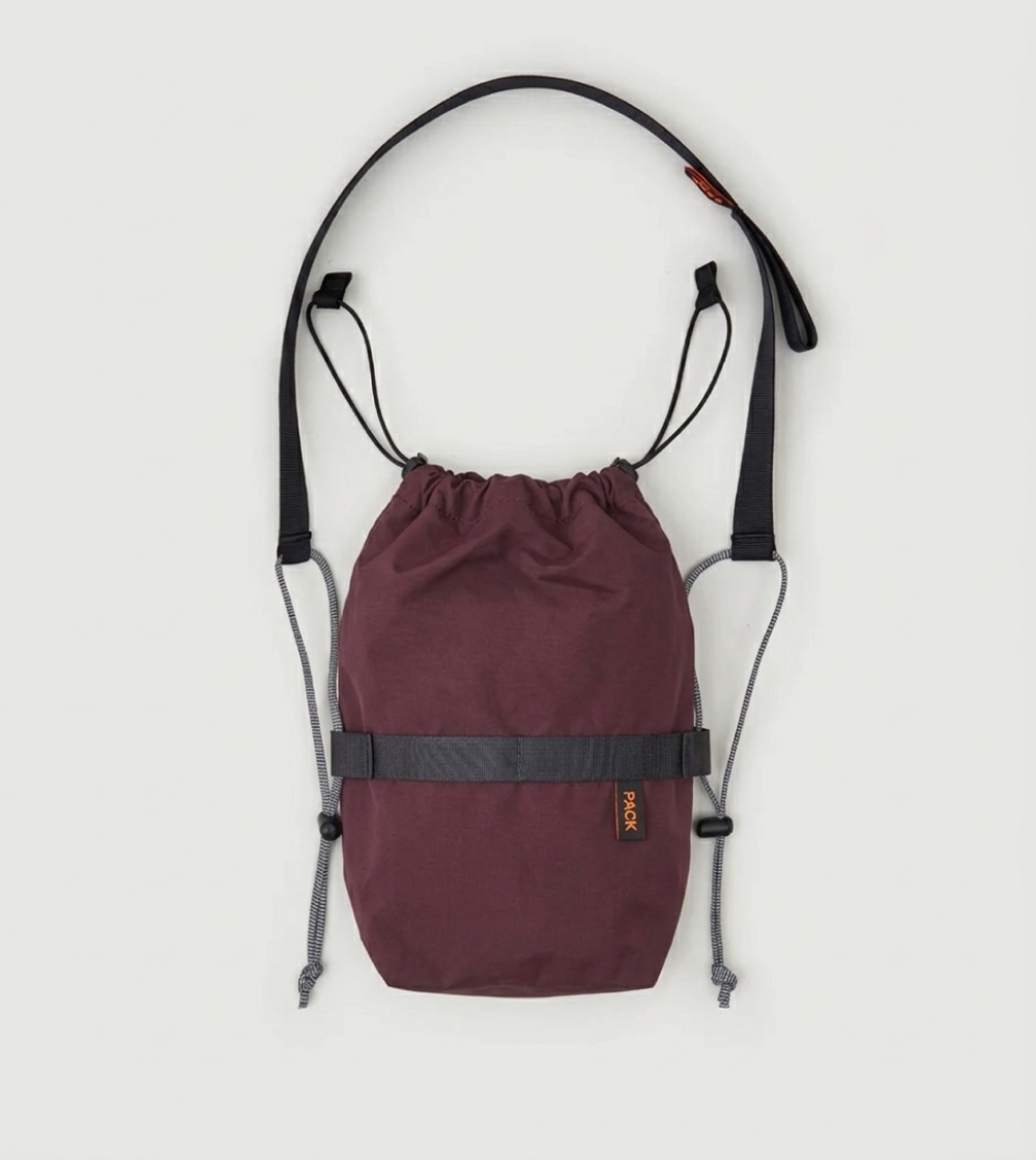 Bolso bandolera pequeño Small Drawstring Sling A110 de PACKBAGS en rojo cinabrio, con cierre de cordón y correa ajustable con detalle reflectante.