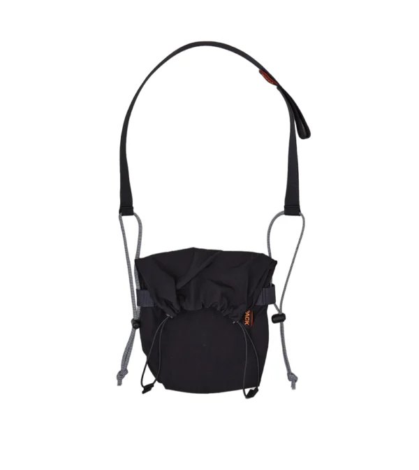 Bolso bandolera pequeño Small Drawstring Sling A110 de PACKBAGS en color negro, con cierre de cordón y correa ajustable con detalle reflectante.