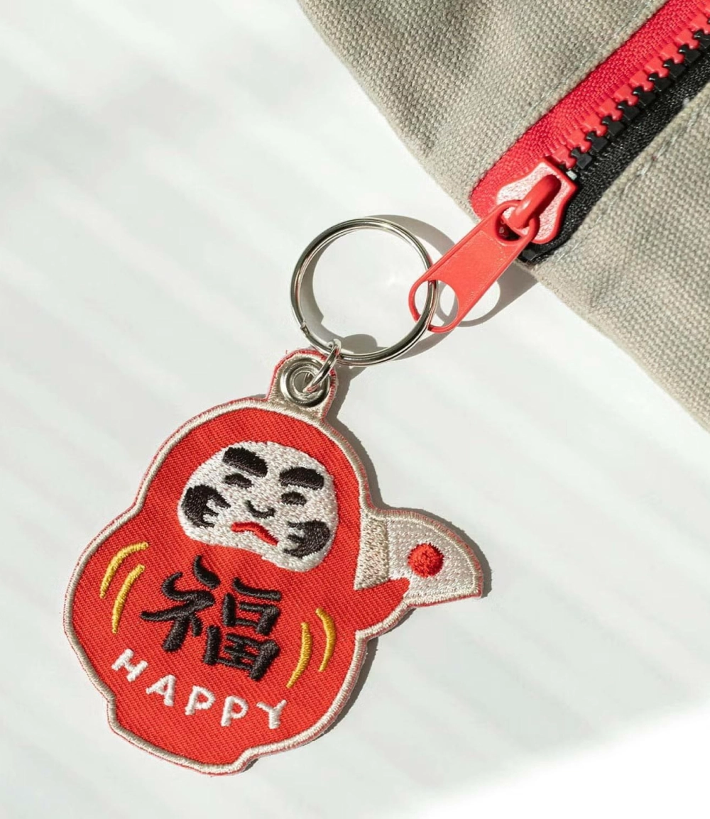 Llavero Daruma japonés bordado de HIGHTIDE, amuleto tradicional de la buena suerte y la perseverancia, ideal para decorar llaves, bolsos y mochilas.