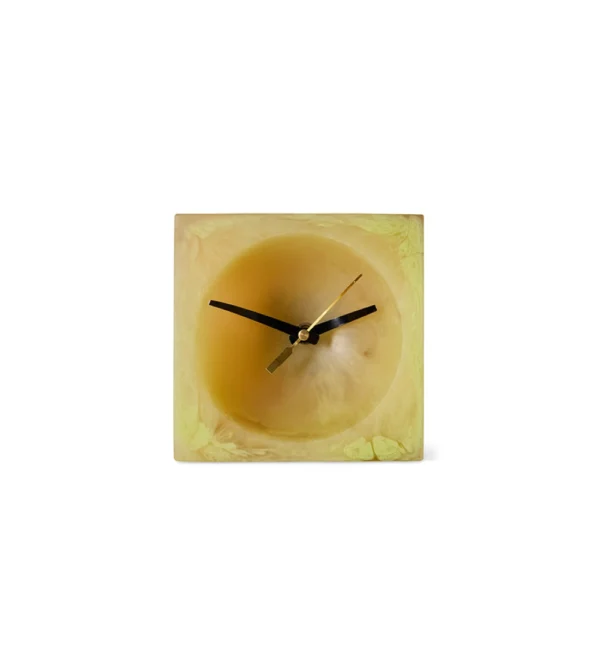 Resin Table Clock Soft Yellow de HKLIVING, reloj de sobremesa de resina amarilla con acabado marmoleado y esfera redonda integrada en una estructura cuadrada.