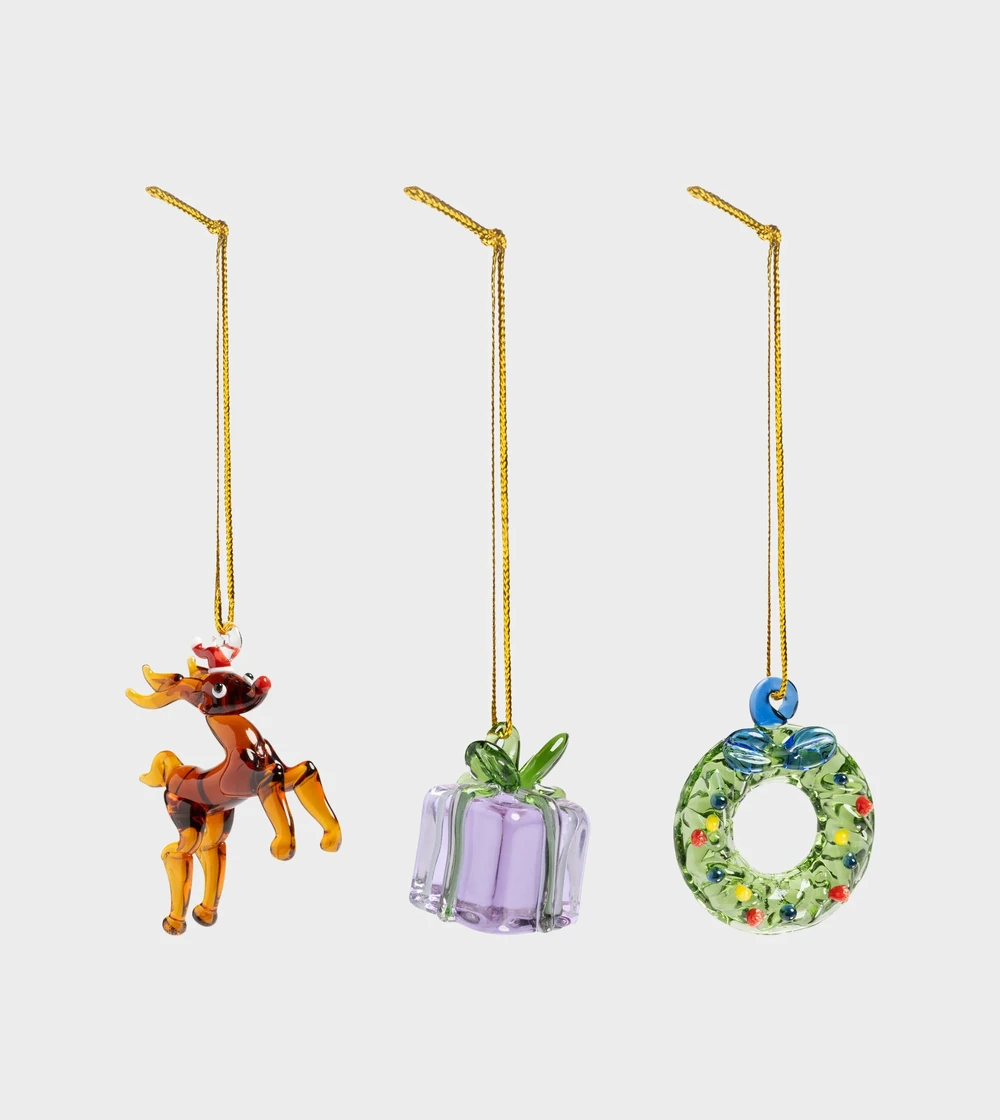 Set de tres adornos navideños Merry #1 de &Klevering, con figuras de reno, regalo y corona navideña, elaboradas en cristal de borosilicato soplado y decorado a mano.
