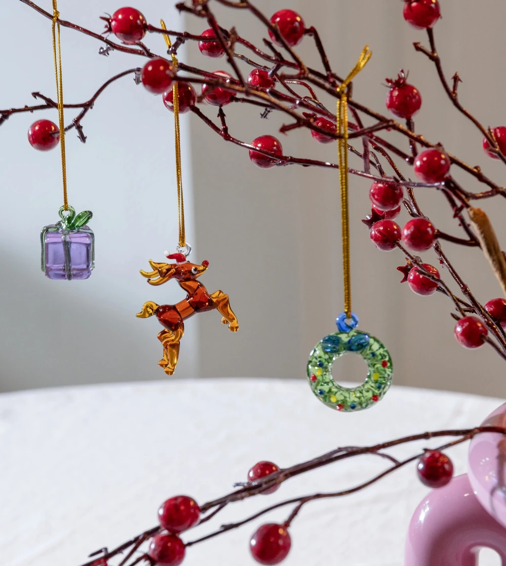 Set de tres adornos navideños Merry #1 de &Klevering, con figuras de reno, regalo y corona navideña, elaboradas en cristal de borosilicato soplado y decorado a mano.