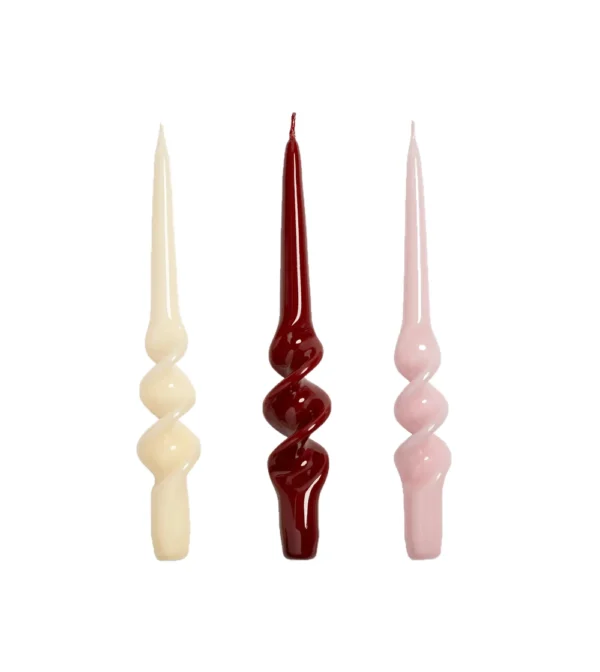 Set de tres velas decorativas Alpha Reds de &Klevering, con formas retorcidas y colores crema, rojo intenso y rosa suave, elaboradas y pintadas a mano.